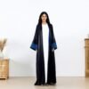 Black open abaya with blue striped cuffs over a white inner